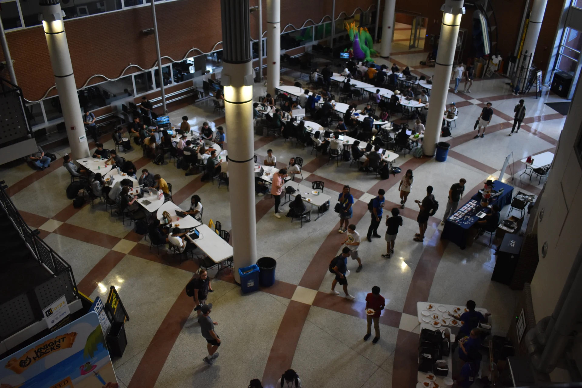 The Knight Hacks event floor, photographed from above, with hackers working at tables throughout the hall.